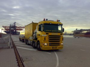 Gele Scania HMF Odin met een container